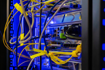 Telecommunication technology equipment - fiber optic cables and switch at server room, data center - close up. Network, transfer, traffic, web, hardware, connection and internet concept