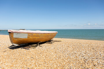  old wooden fishing boat moored on a pebble beach