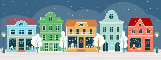 Street with shops and houses at winter night on Christmas eve. Sweet shop, candy store, confectionery, bakery with Christmas decoration. Winter town, city panorama. Christmas shop, street.