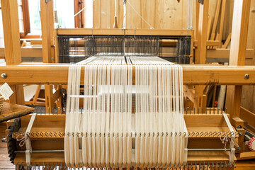 close up of weaving machine. A loom machine for clothing or woven label. Weaving machine for...