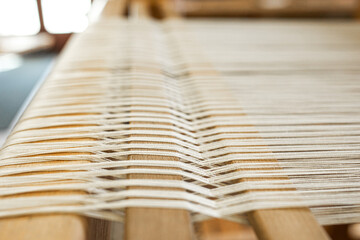 close up of weaving machine. A loom machine for clothing or woven label. Weaving machine for...