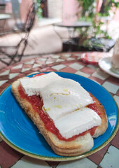 Cottage cheese and tomato toast over glazed tile mosaic table
