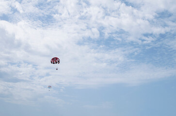 Parasailing over the sea on the background of clouds