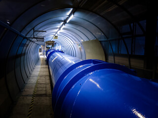 Illuminated gas or oil, orange pipeline in dark tunnel