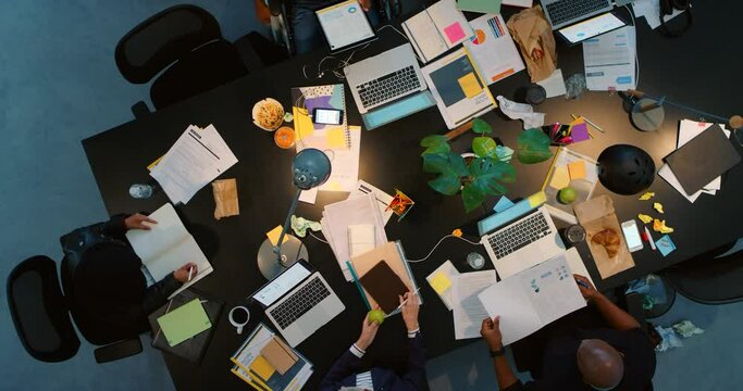 Collaboration, planning and teamwork in a busy office with corporate employee working late on innovation and new idea. Above view of colleagues sharing strategy and vision while working overtime