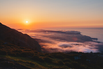 coastal landscape with sea of clouds from a mountain at sunset