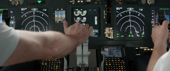 DOLLY IN Commercial aircraft pilots controlling airplane throttle lever during the flight or take off. View from inside the cabin. Real aircraft, daytime shot - Powered by Adobe