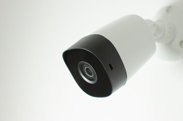 CCTV videocam, CFTV security camera, white camera with secure circuit, theft protection. Surveillance view.