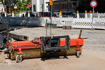 Tow hitch with a rotating brush for cleaning the road surface.