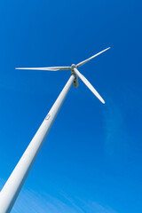 Shot of windmill spinning against the blue sky.