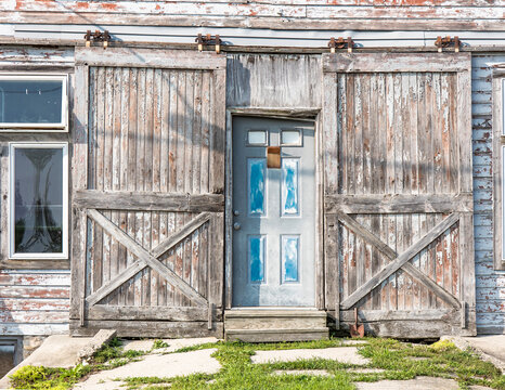 The front doors of a repurposed old livery stable with modern windows on the left.