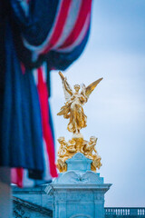 Golden Victoria Memoerial in front of Buckingham Palace framed by union flag at dusk - Portrait 