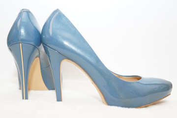 Blue sexy high-heeled shoes isolated on a white carpet.