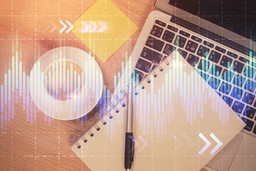 Double exposure of forex chart drawing over table background with computer. Concept of financial research and analysis. Top view.