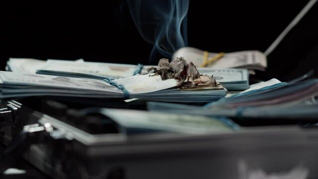 Burning American hundred dollar banknotes, Flame of fire from money. Rich person having stacks of 100 US dollars in metallic suitcase. Paper money loss, financial crisis and depressed economy. 