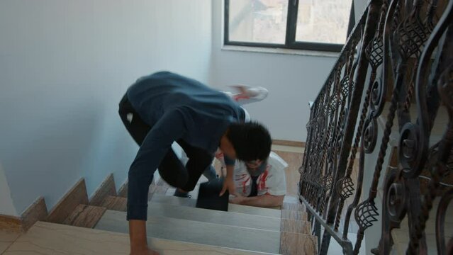 Frightened worker on emergency stairway running away from scary looking doomsday zombies. Brain-eating bloody crawling monsters chasing apocalypse survivor on office hallway stairs.