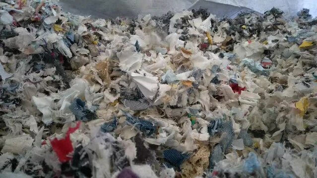 Slow motion Closeup Shredded Textile residue falling to a big bag. Concept ecology and nature. Textiles are not recycled properly nowadays. High quality footage. Closeup