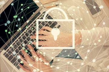 Double exposure of woman hands working on computer and lock hologram drawing. Top View. Security concept.