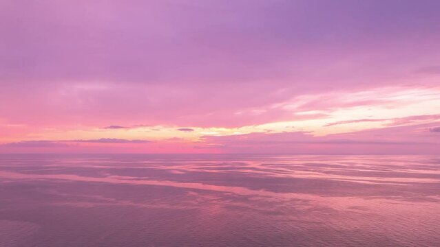 Sun Setting at the Horizon. Pink Vibrant Sky Cloudscape. Beautiful sunset ocean view. Cape Breton, Nova Scotia, Canada.