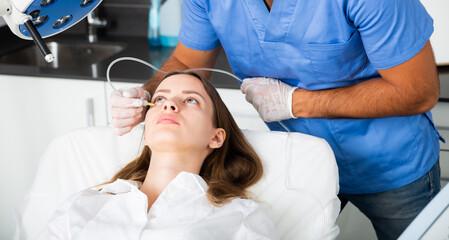Young woman receiving innovative anti-aging carboxytherapy procedure for face skin in aesthetic medicine office, infusing of carbon dioxide under skin for collagen boosting