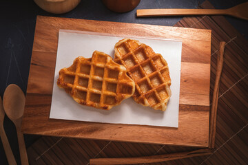 Waffle in wooden plate on wooden table, Freshly baked Waffle on brown wooden table.