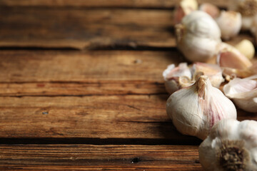Fresh organic garlic on wooden table, closeup. Space for text