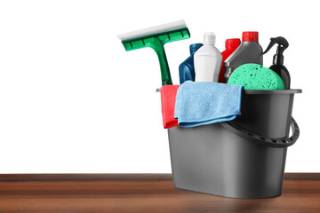 Grey bucket with car care products on wooden table against white background © New Africa