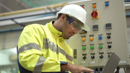 Professional Asian mechanical engineer inspecting the machines in the automated manufacturing factory.