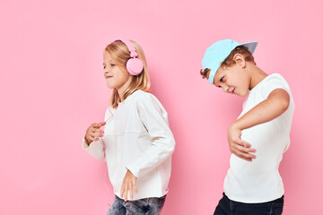 a boy in a cap and a girl dancing entertainment pink color background