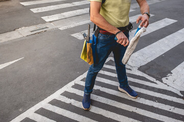 Janitor worker and handyman with cleaning tools in crosswalks in a parking lot