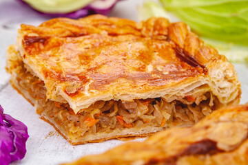 Homemade cabbage pie on wooden rustic background. Close up