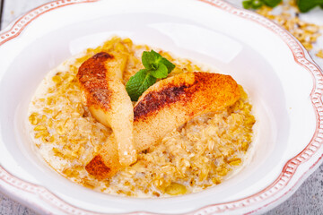 Oatmeal porridge with pear in white plate. Close up