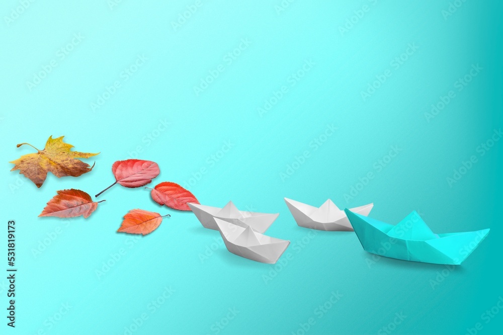 Poster Paper boat with fresh tree leaves on blue background.