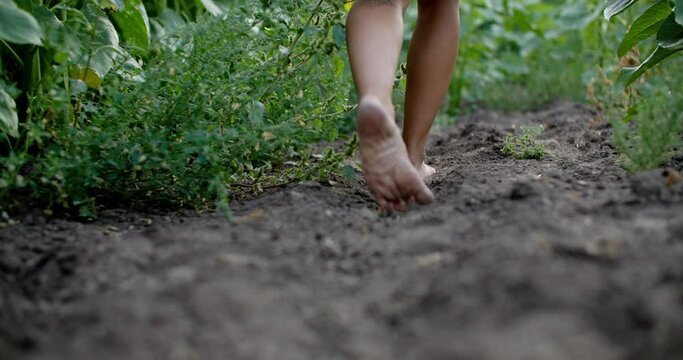 Girl walking barefoot through rich soil