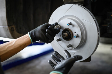 Auto mechanic installing six slot brake rotors.	