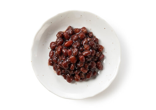 Boiled azuki beans in a dish placed on a white background.