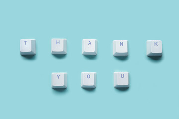 Word THANK YOU written on computer keyboard keys isolated on a turquoise