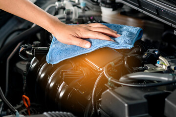 Plakat hand of a man holding a blue cloth caring, maintenance car and cleaning And engine car room
