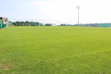 A view of the soccer driving range on a clear day. grass field.