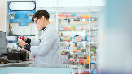 A male pharmacist checks drug stocks in a community pharmacy.