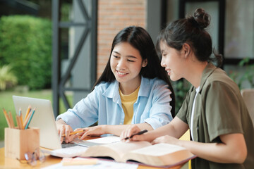 Young asian students campus helps friend catching up and learning.