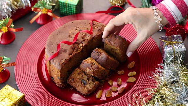 Woman serving homemade Christmas plum cake India Kerala. Fruitcake of dried fruit, nuts, spices , rum New Year party, Easter, Christmas Eve. Indian Christmas celebration 4K video , footage