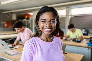 Portrait of young hispanic latin teenage student woman smiling at camera standing at technology classroom