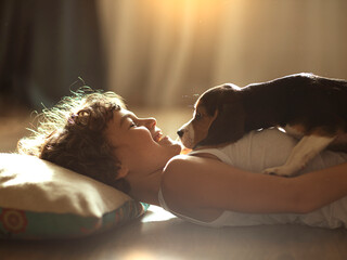cute boy playing with beagle puppy