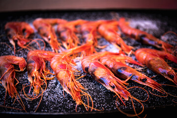 cooking tiger shrimps on iron griddle. selective focus. close up