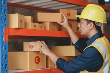Asian male warehouse worker check and count inventory in the warehouse for accuracy and ease of...