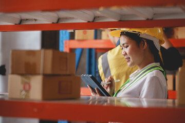 Asian female warehouse worker check and count inventory in the warehouse for accuracy and ease of...