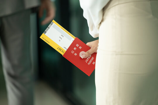 Japanese citizen handle Japan passport and flight ticket waiting to check in fly back to Japan or travel other country