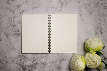 Notebook with roses over the grey background. 