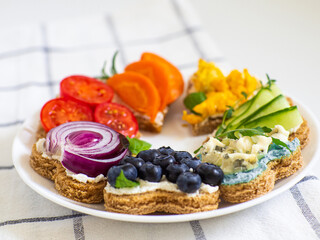 Rainbow sandwiches heart shape on white table. Breakfast bread rainbow sandwiches with colorful vegetables. Love, Valentines day food and LGBT pride flag concept. Copy space. Top view. Healthy food.